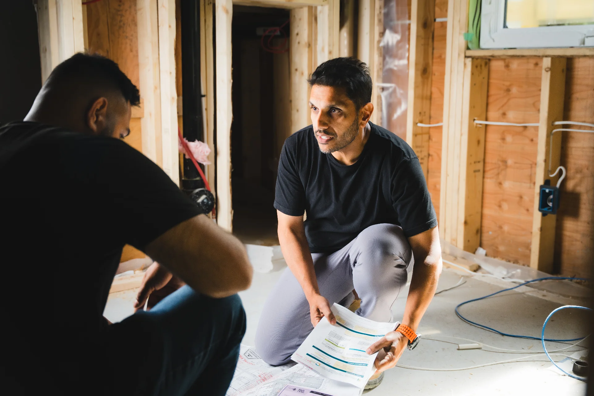 Sanj Aggarwal reviewing plans on a job site with a team member